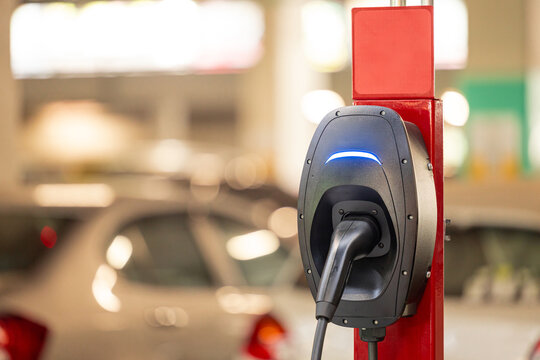 EV charging and electric car, Electric car charging station for charge EV battery, Plug for vehicle with electric engine, EV charger clean energy, Charging point at car parking lot.