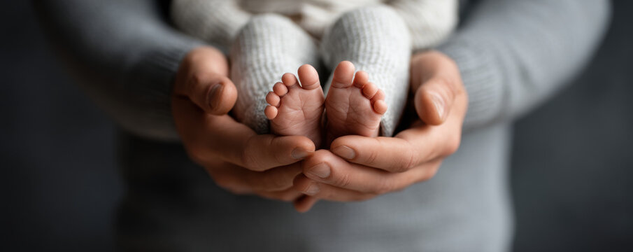 Father day dad daddy baby foot parent hand newborn infant family love care tenderness closeup of tiny feet held gently for father day celebrating