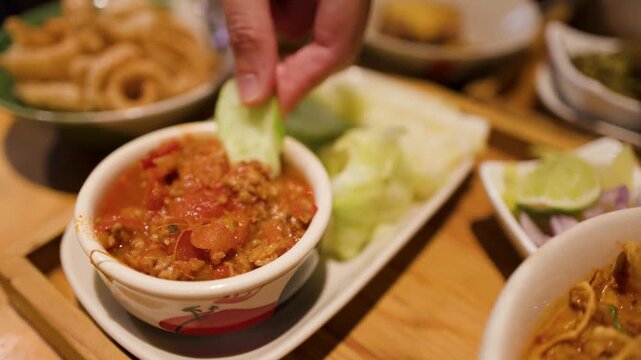 Dipping Crispy Pork Skin and Cucumber into Northern Thai Nam Prik Ong