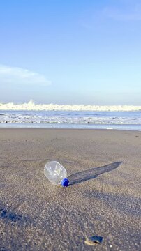 Plastic bottle trash lying on sandy beach