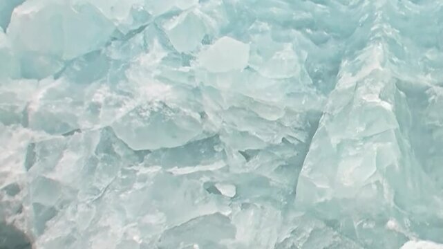 Glimpse into the heart of Arctic travel, where a vessel pushes through a dazzling expanse of broken sea ice. Brilliant blue and white shards shimmer, revealing the immense power of the frozen Ocean.