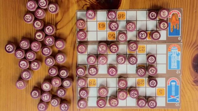 Top down push in on vintage bingo barrels and old lottery cards over rustic wooden table, camera descending from ceiling wide view into blurry extreme close up with nostalgic retro lotto atmosphere