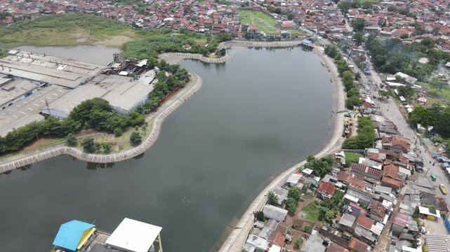 Aerial view of urban lake or water retention basin surrounded by residential houses