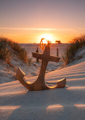 wooden anchor on the beach in sunset light © Jenny Sturm