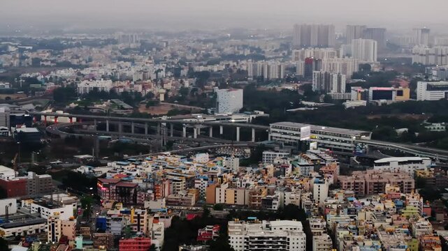 residential buildings with tower apartments, flyovers, metro line, haze and Infosys metro station at Electronic City, Bengaluru, karnataka, india. day time, pan shot, drone shot, 4k.