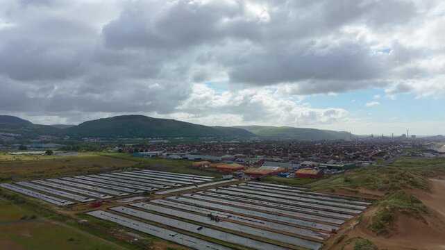 Rising Aerial View of Commercial Ragworm Farm and Marine Bait Production. Sediment beds and water filtration systems used to cultivate ragworms for the global fishing bait market. United Kingdom. 4K.