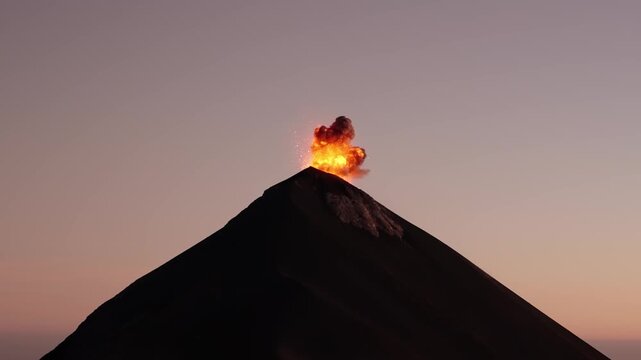 Fuego Volcano explosive lava burst glowing above summit at sunset Guatemala