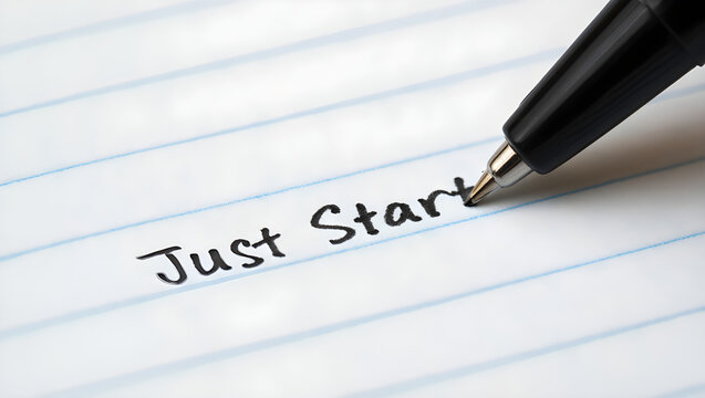 A close up macro photograph features a black ink pen writing the motivational phrase just start on white lined notebook paper to inspire productivity and encourage beginning a new project.