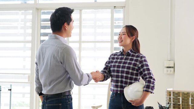 Design team Architect and Engineers shake hands at a business conference on  construction project.