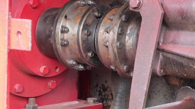 Close-up of a heavy-duty industrial mechanical shaft coupling connecting two rotating shafts on heavy machinery.