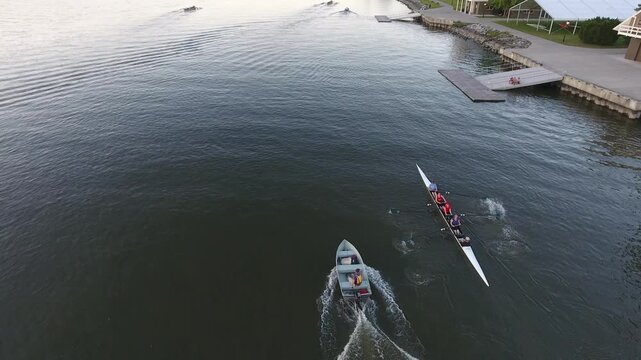 Aerial view of rowing shells gliding on the Hudson River near the Hudson River Rowing Association building and docks in Poughkeepsie, New York, United States.