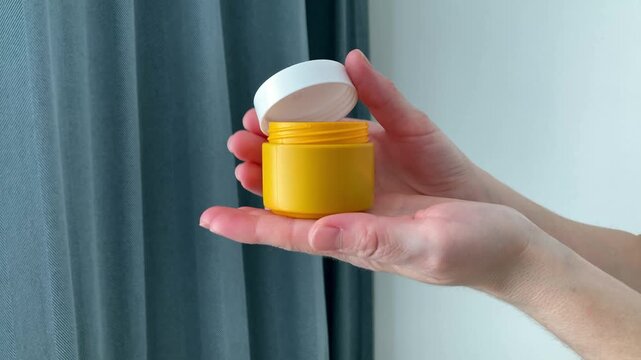 A woman holds a jar of iodine ointment in her hands. The compact shape and reliable lid make the product easy to use and store. Comfort, hygiene and convenience in daily health care