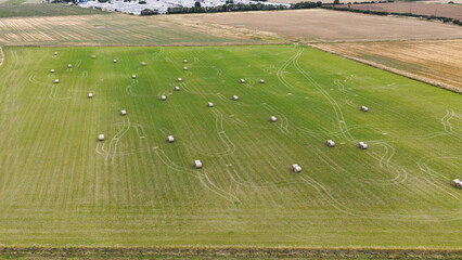 Fototapeta premium Aerial View of Round Hay Bales on Green Field in Hope Valley