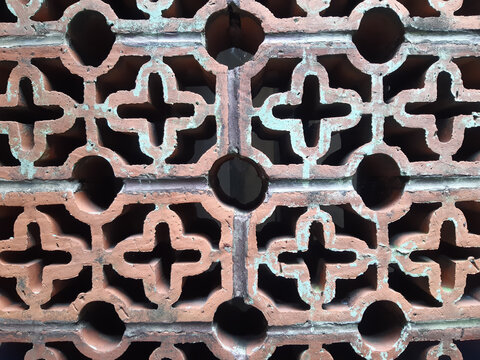 Close-up of a Red Brick Wall with Ventilation Holes and Rough Texture