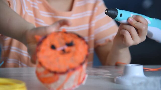 Little girl creating colorful toy with 3D printing pen at table, slow motion video of child creativity, education and modern technology hobby concept