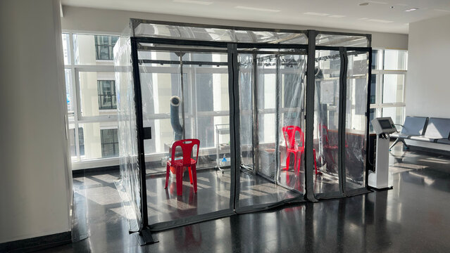 Portable isolation booths and health screening stations inside an airport terminal, showcasing pandemic prevention measures and travel safety protocols for international passengers.
