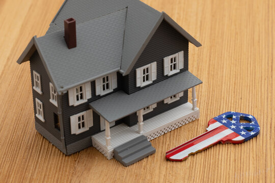 House with USA flag key on wood desk for American dream