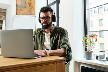 Fototapeta premium Young handsome man engaged in creative work at a cozy workspace with natural light