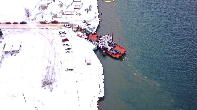 Drone footage capturing a ferry transporting vehicles between the Upper Peninsula and Sugar Island.