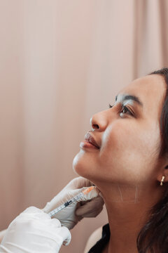Female patient receiving fat dissolving mesotherapy injections at an aesthetic clinic for double chin reduction and jawline contouring