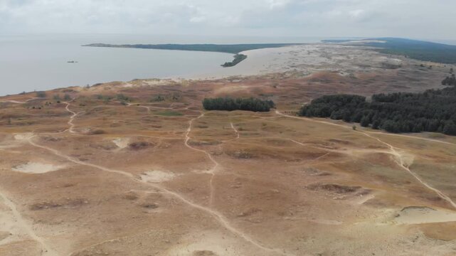 An aerial, high angle, birds eye view captures the vast, sandy landscape of the Parnidis Dune in the Curonian Spit National Park, near Nida, Lithuania.