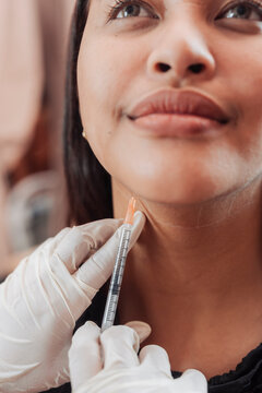 Female patient receiving mesotherapy injection at an aesthetic clinic for jawline sculpting and double chin fat reduction