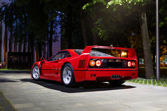 Red Ferrari F40 supercar in night city scene. Iconic Italian sports car with aggressive styling, urban lights, and legendary performance. Concept of speed, prestige, and luxury lifestyle.
