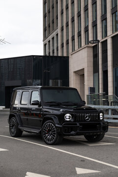 Black Mercedes-Benz G-Class AMG in urban city setting on asphalt road. Luxury SUV with iconic design, powerful presence, and premium styling. Concept of prestige, status, performance and modern