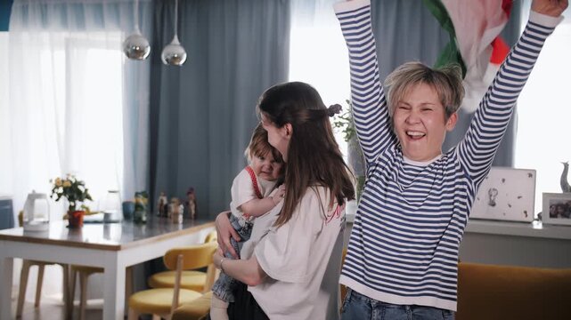 Happy Italian family celebrating football victory together at home with national flag