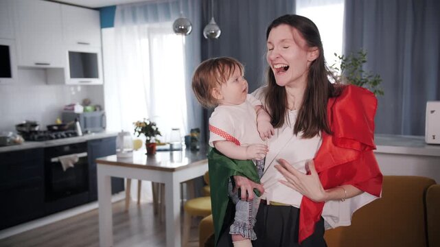 Italian football fan mother with toddler emotionally watching soccer match at home