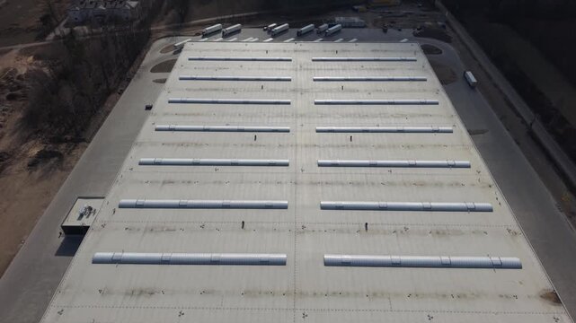 Aerial Distribution Hub Trailers Parked Alongside Roof Vents And Service Lanes, Fleet Staging For Dispatch, Drone Orbital Shot Reveals Organized Loading Lines, Asphalt Approach Roads