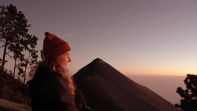 Traveler watching Fuego volcano at sunset from Acatenango basecamp in Guatemala