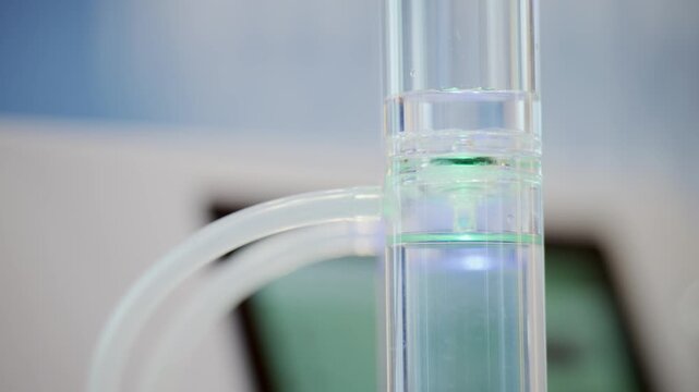 Close up of transparent electrolysis chamber with small hydrogen bubbles forming inside laboratory tubing during clean energy and green hydrogen research