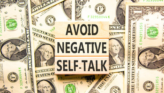 Avoid negative self-talk symbol. Concept words Avoid negative self-talk on beautiful wooden blocks. Beautiful dollar bills background. Business psychology avoid negative self-talk concept. Copy space.