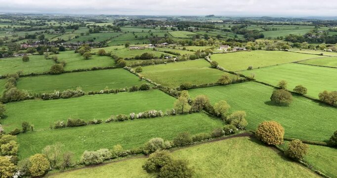 Aerial drone footage taken in Bedlam Harrogate North Yorkshire English countryside showing green farmland hedgerows rural fields scattered trees and agricultural landscape in the spring time