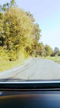 Car dashboard view while traveling on the countryside road on a sunny day