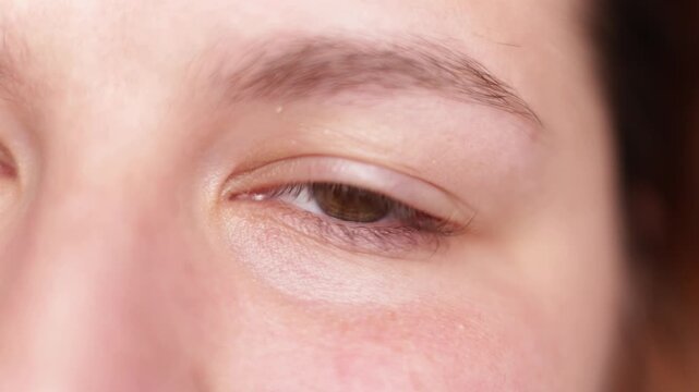 Close-up of a human eye with brown iris and natural skin texture