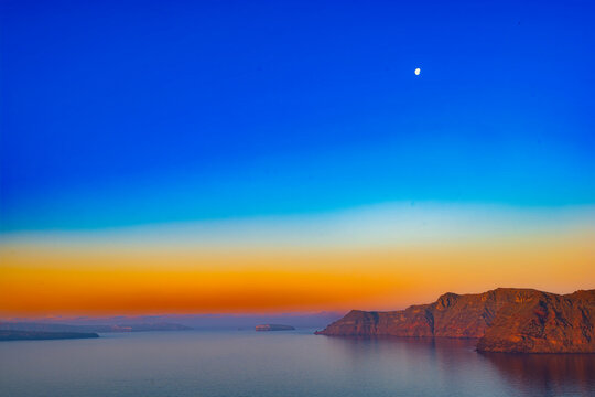Orange dawn horizon over Santorini caldera cliffs