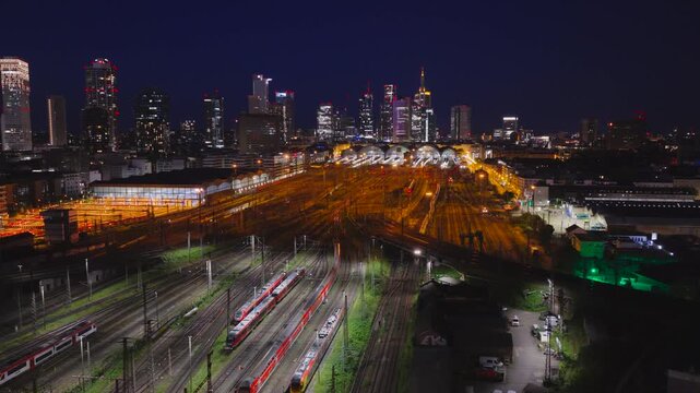 Aerial view of Hauptbahnhof with illuminated train tracks and the city skyline at night in Frankfurt am Main, Hessen, Germany.