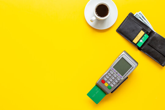Contactless payment in cafe &mdash; credit card, coffee cup and POS terminal, small business lifestyle, top view