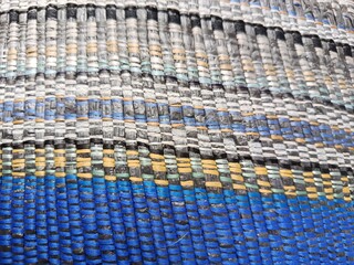 Naklejka premium Macro Texture of a Colorful Woven Synthetic Mat with Vibrant Blue and Yellow Stripes
