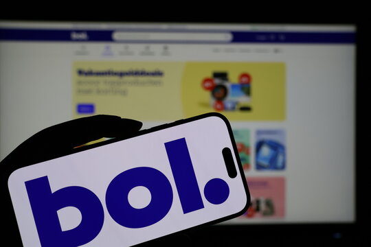 Kiel, Germany - 05-20-2026: Smartphone displaying Dutch ecommerce company bol.com logo in front of companys webpage