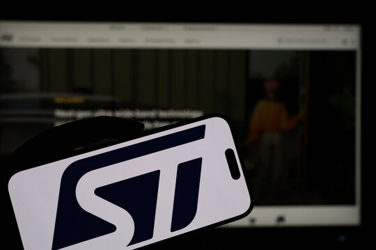 Kiel, Germany - 05-20-2026: Smartphone displaying Swiss semiconductor company STMicroelectronics logo in front of companys webpage