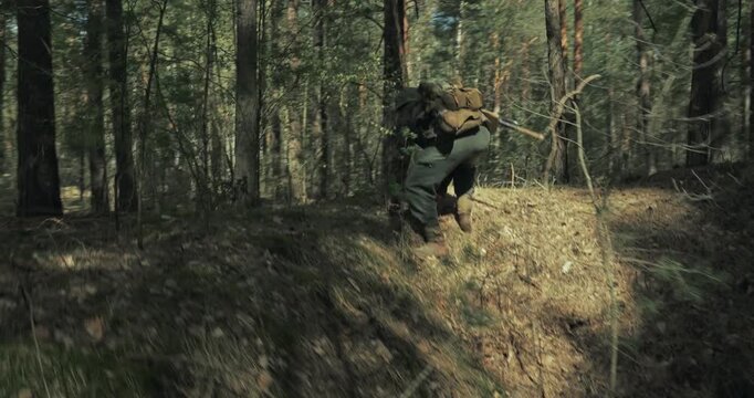 Reenactor Dressed As German Infantry Soldier Takes Cover In Pit. Soldier With Rifle