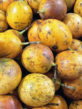 The image displays a pile of Sweet Granadilla (scientifically known as Passiflora ligularis). In Indonesia, especially in West Java, this fruit is commonly called Markisa Konyal.