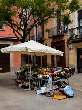 Parada de fruta en una plaza bajo un parasol