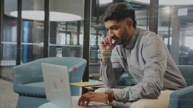Developer responding to onscreen code prompt, typing on laptop in coworking lounge applying edits