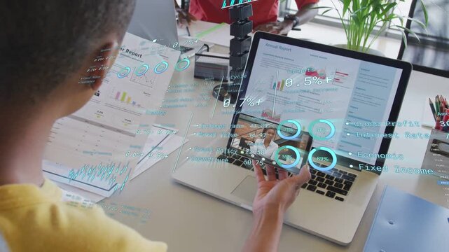 Data analyst holding phone over laptop, shifting phone while AR charts updating, peer gesturing