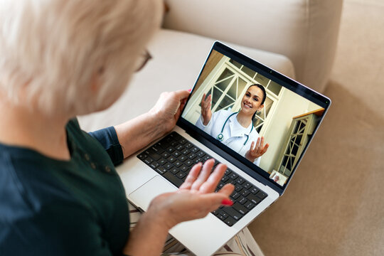Senior woman having telehealth consultation on laptop