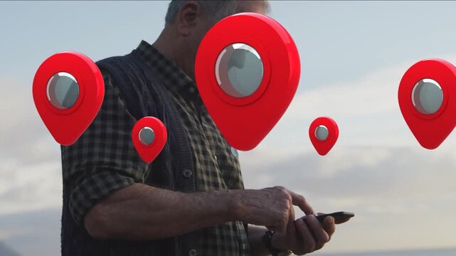 Senior man tapping smartphone by sea, checking locations, map tech showing red pins obscuring face